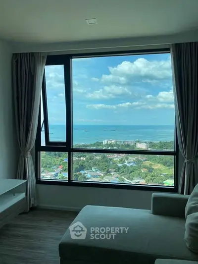 Stunning high-rise living room with panoramic ocean view through large window.
