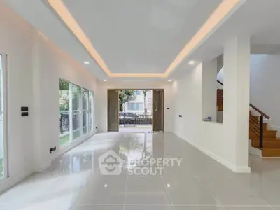 Spacious modern living room with glossy tiles and large windows for natural light.