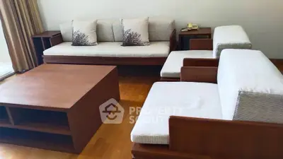 Spacious living room with elegant wooden furniture and cozy seating area.