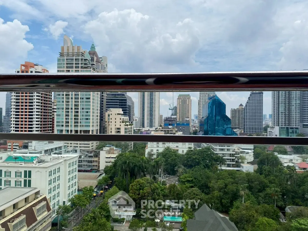 Stunning cityscape view from a high-rise balcony overlooking urban skyline and lush greenery.