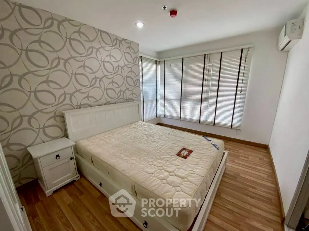 Spacious bedroom with modern decor and large windows for natural light.