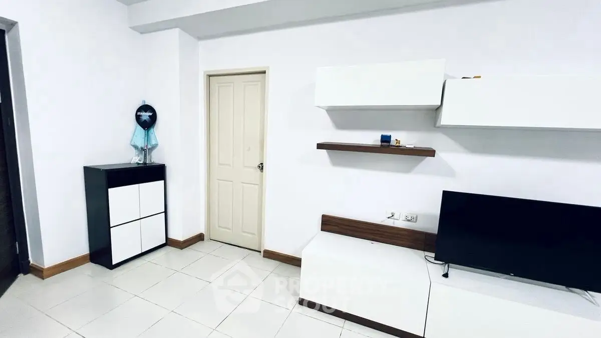 Modern minimalist living room with sleek furniture and wall-mounted TV.