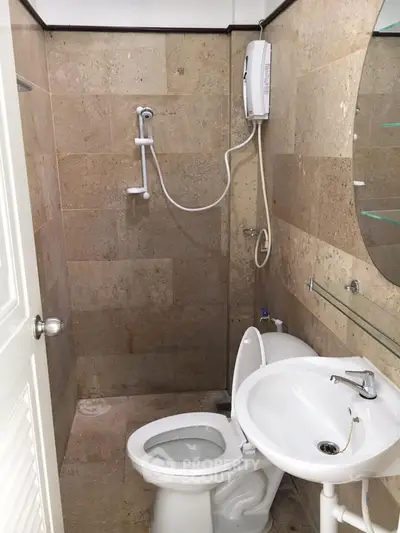 Compact bathroom with shower and modern fixtures in a cozy real estate property.