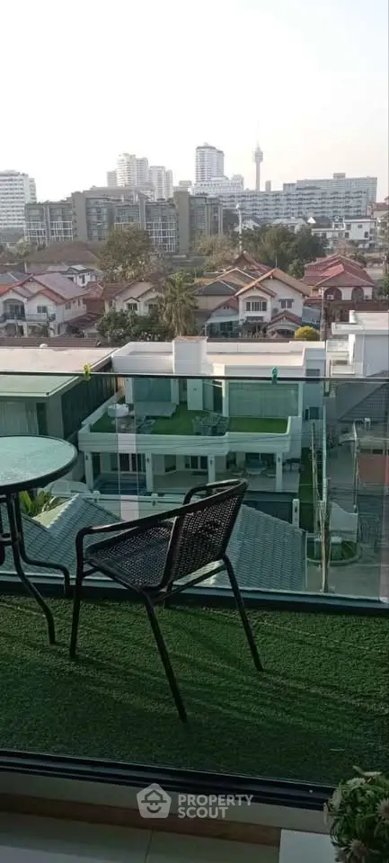 Stunning balcony view overlooking cityscape with modern buildings and lush greenery.