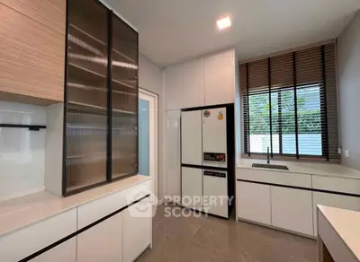 Modern kitchen with sleek cabinetry and large window for natural light