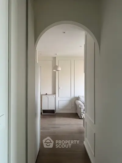 Elegant hallway leading to a cozy living room with modern decor and soft lighting.