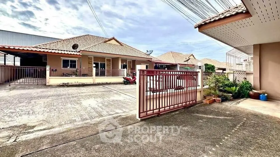 Charming suburban house with gated entrance and tiled roof in a peaceful neighborhood.