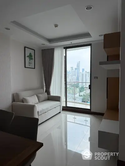 Modern living room with city view, sleek furniture, and large window in high-rise apartment.