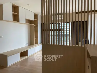 Modern living room with wooden partition and built-in storage, featuring a sleek and minimalist design.
