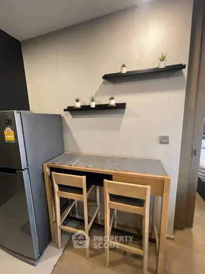 Modern kitchen corner with sleek fridge and minimalist dining setup