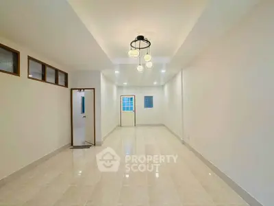 Spacious and bright interior with modern lighting and tiled flooring, perfect for versatile living arrangements.