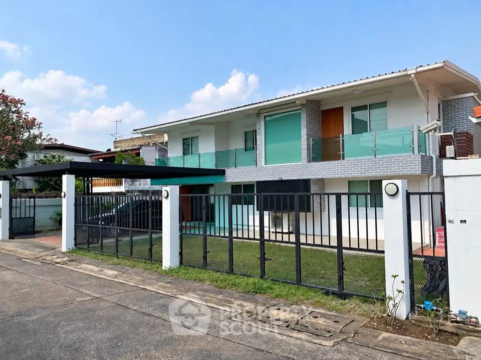 Modern two-story house with sleek design and spacious front yard in a serene neighborhood.