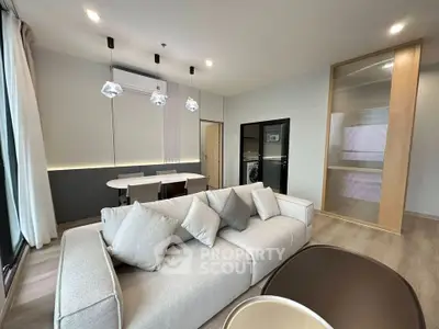 Modern living room with elegant decor and dining area in a stylish apartment.