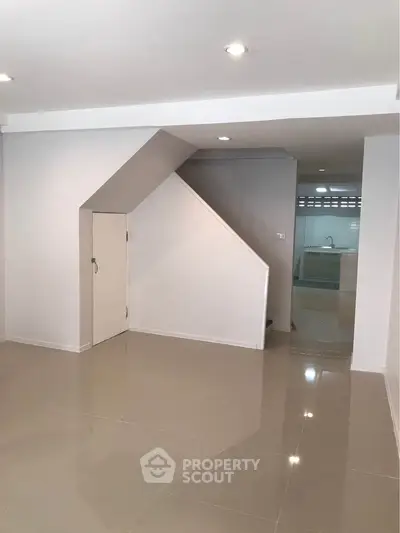 Spacious modern interior with sleek tiled flooring and minimalist design, perfect for contemporary living.