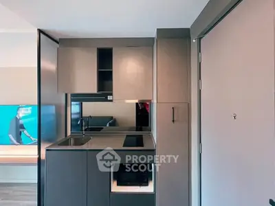 Modern compact kitchen with sleek cabinetry and built-in appliances in a stylish apartment.