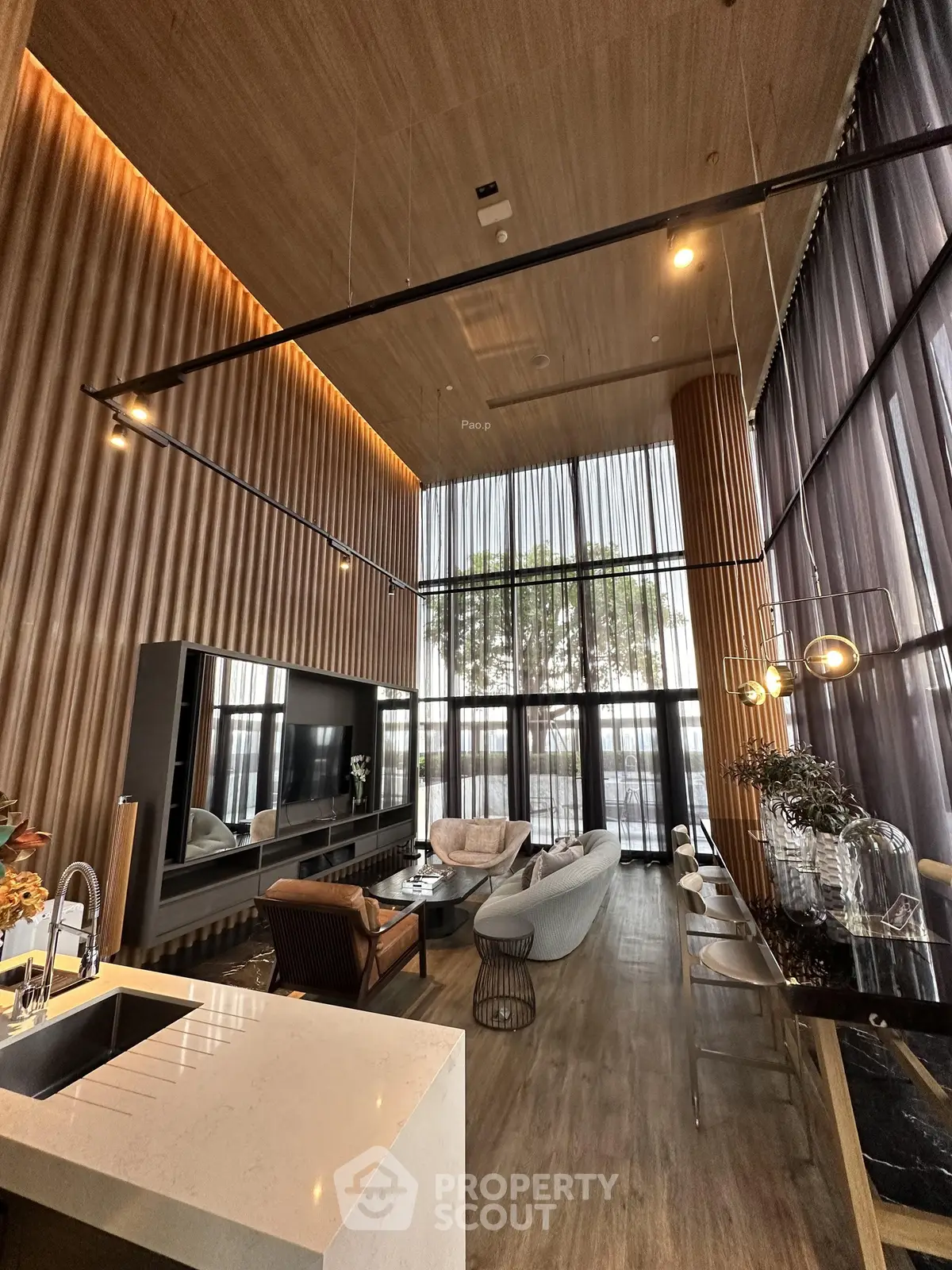 Luxurious high-ceiling living room with modern decor and large windows