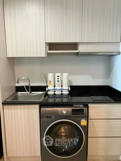 Modern kitchen with washing machine and sleek cabinetry