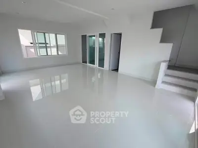 Spacious modern living room with glossy white tiles and large windows