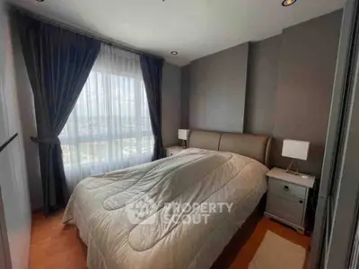 Cozy bedroom with large window and elegant curtains in modern apartment