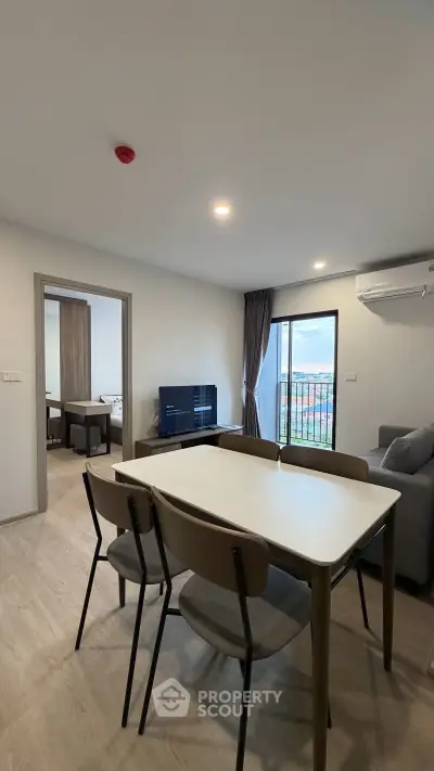 Modern living room with dining area and balcony view in a stylish apartment.