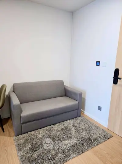 Cozy modern living room corner with a sleek gray sofa and plush rug