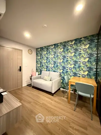 Charming living room with floral accent wall and cozy seating area in modern apartment.