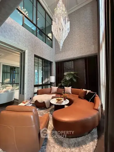 Luxurious living room with elegant chandelier and modern leather furniture