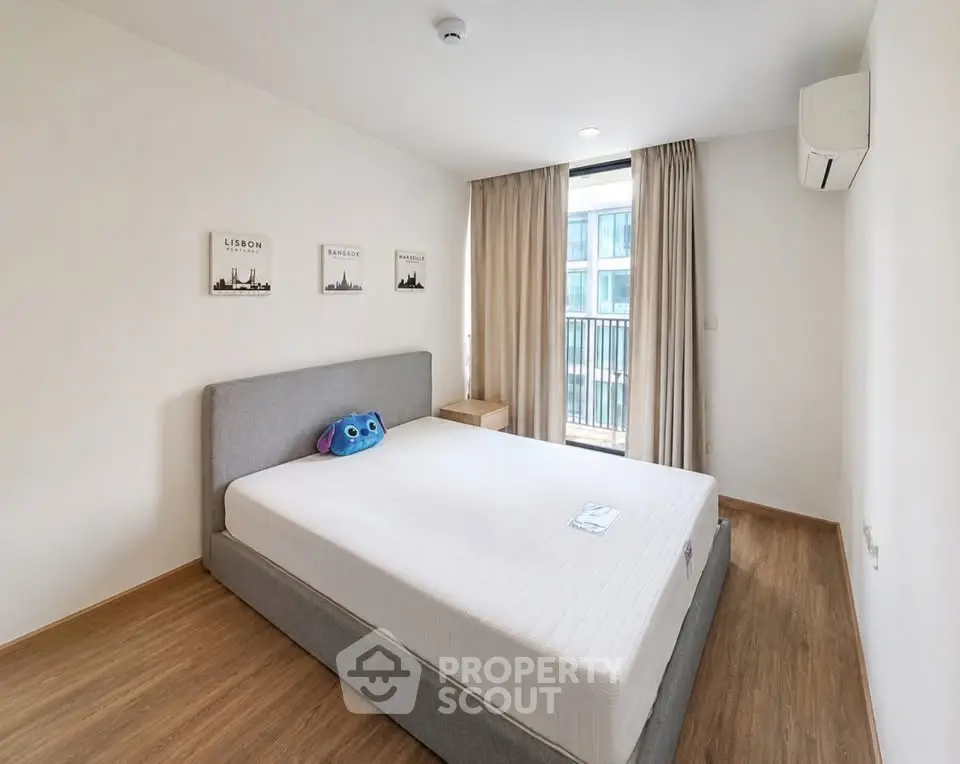 Modern bedroom with large window and minimalist decor in urban apartment