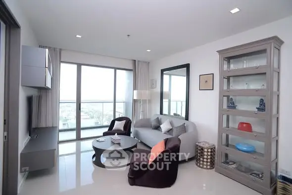 Modern living room with large windows and stylish furniture in a high-rise apartment.