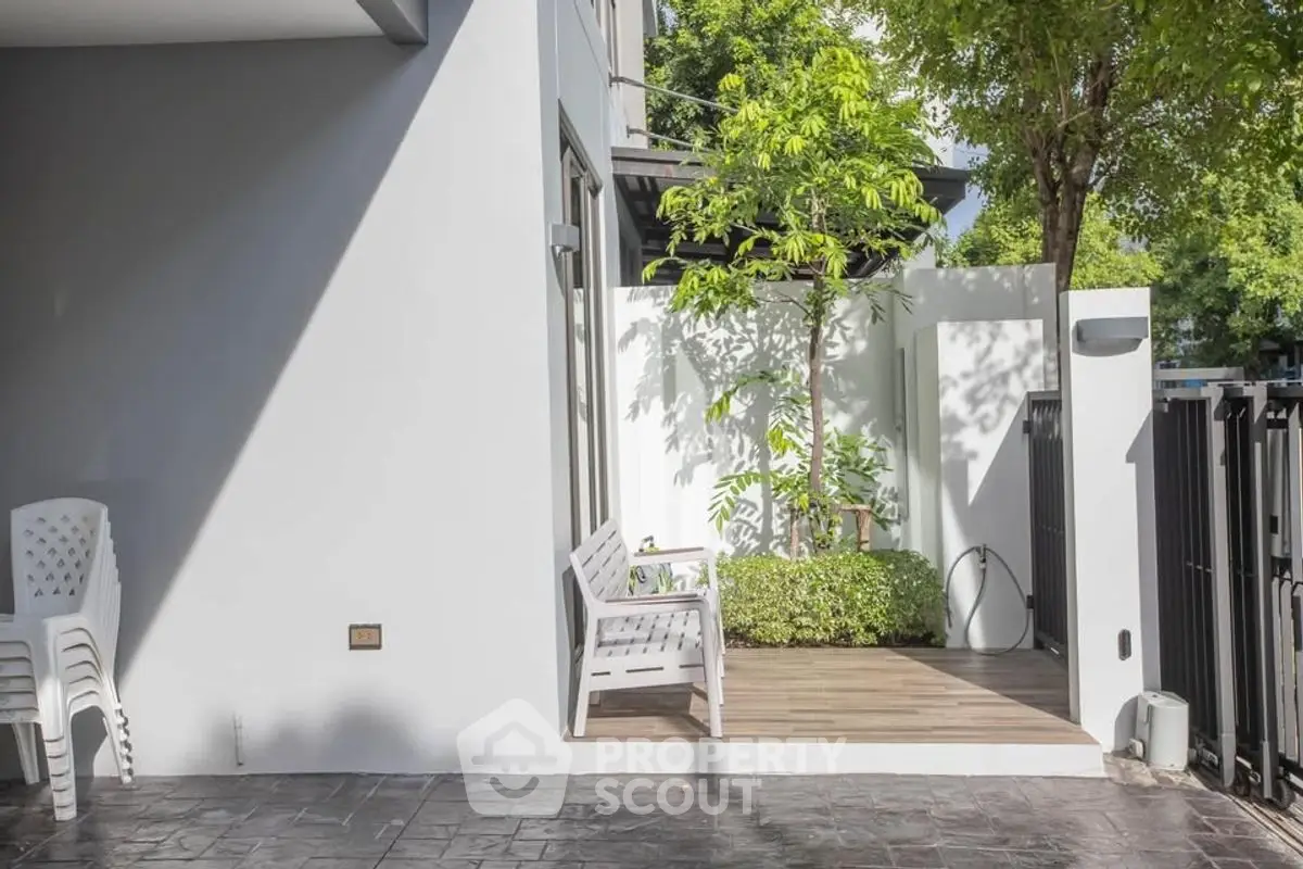 Charming outdoor patio with seating and lush greenery in modern home