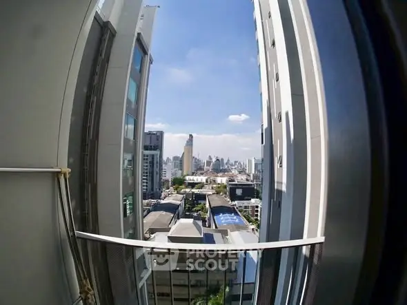 Stunning cityscape view from a high-rise balcony, showcasing urban skyline and modern architecture.