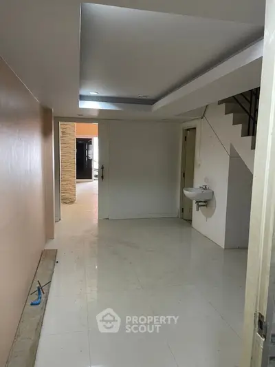 Spacious entryway with modern staircase and sleek tile flooring