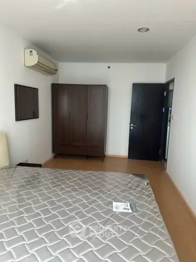 Spacious bedroom with air conditioning and wooden wardrobe in modern apartment