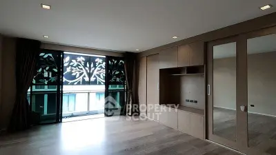 Spacious modern living room with large windows and elegant wooden flooring.