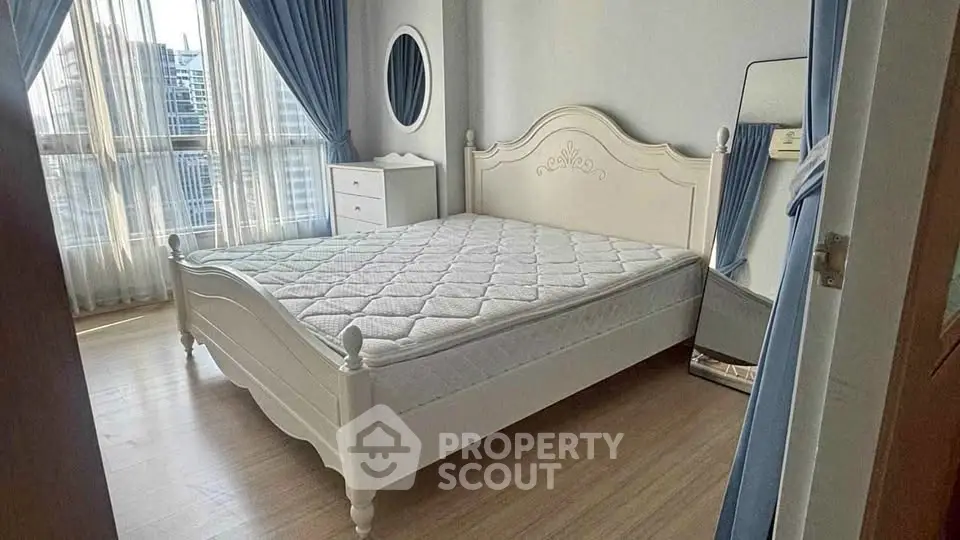 Elegant bedroom with large window and stylish white furniture, perfect for a serene living experience.