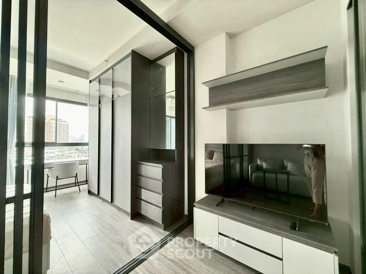Modern apartment interior with sleek design and large windows offering city views.