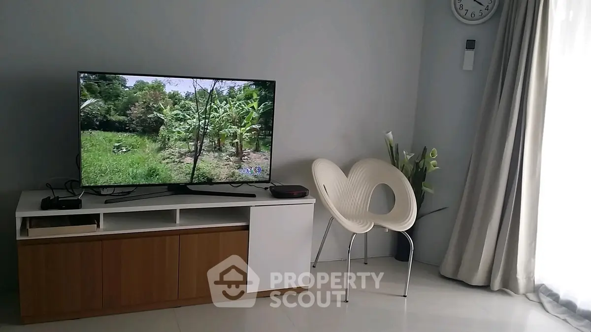 Modern living room with sleek TV setup and stylish chair, perfect for relaxation and entertainment.