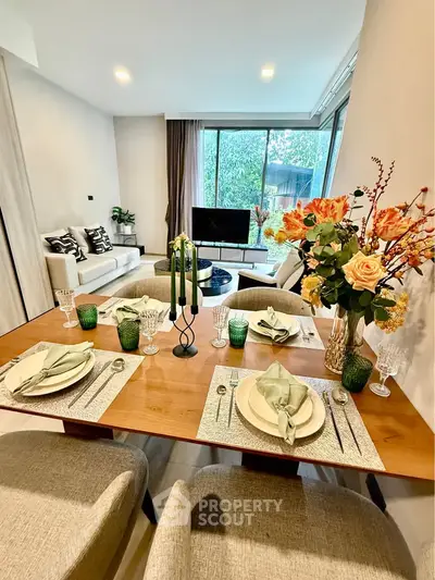 Elegant living room with dining area, modern decor, and garden view.