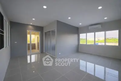 Spacious modern living room with large windows and sleek tile flooring