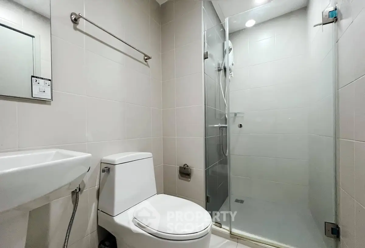 Modern bathroom with glass shower and sleek fixtures in a contemporary apartment.