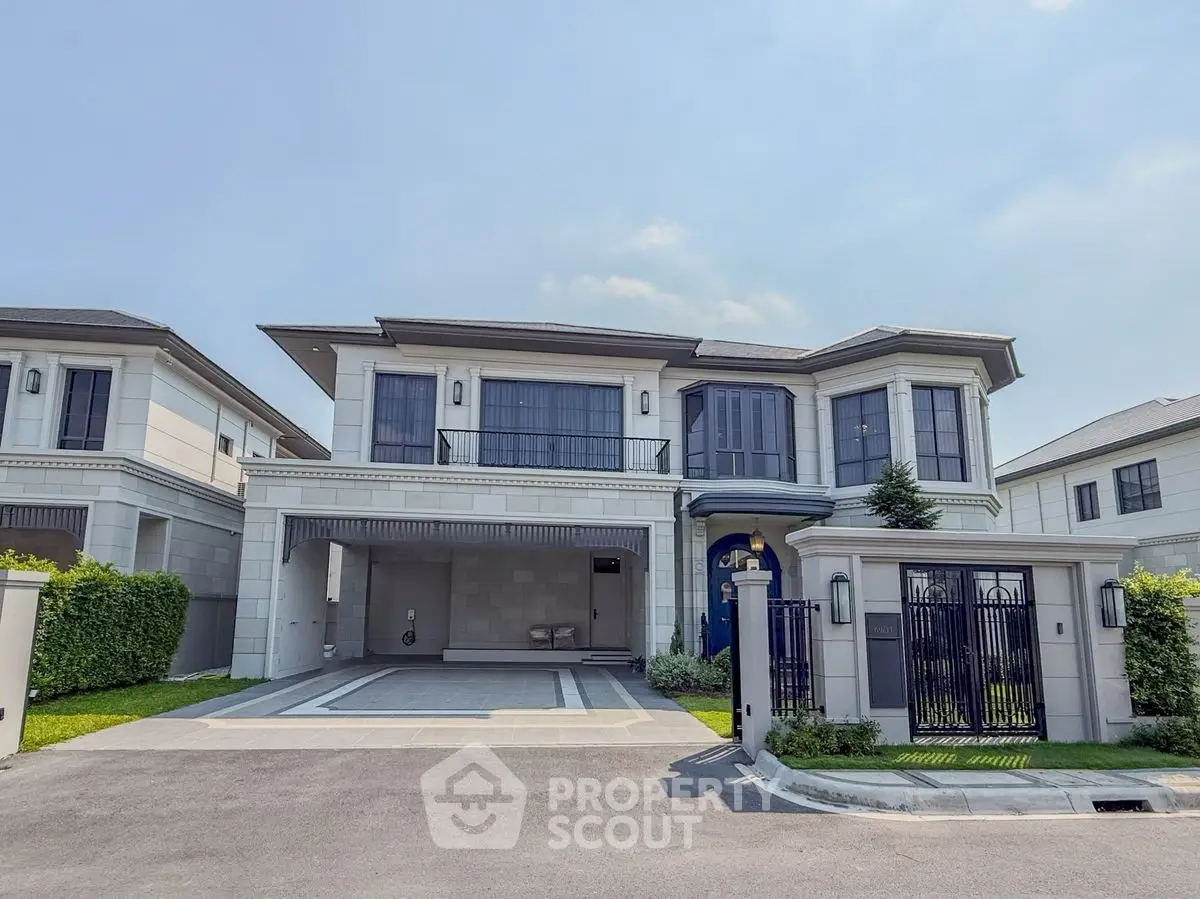 Luxurious modern house with spacious driveway and elegant facade in upscale neighborhood.
