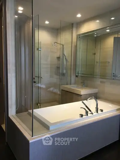 Luxurious modern bathroom with glass shower and sleek bathtub design.