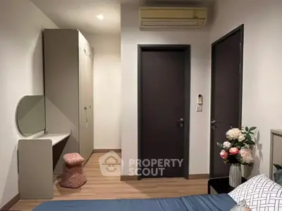Cozy bedroom with modern decor and air conditioning, featuring a stylish wardrobe and vanity area.