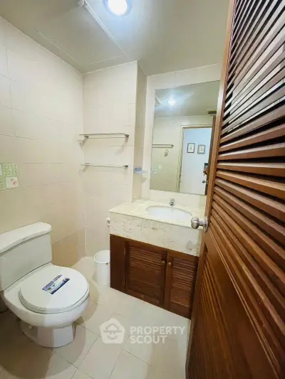Charming bathroom with modern fixtures and ample storage in a cozy real estate property.