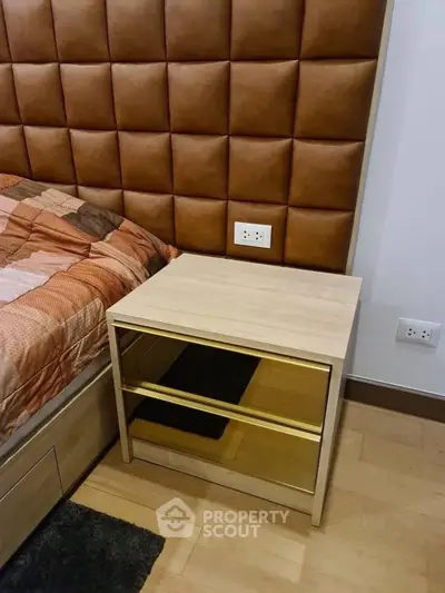 Modern bedroom with stylish padded headboard and sleek wooden nightstand.