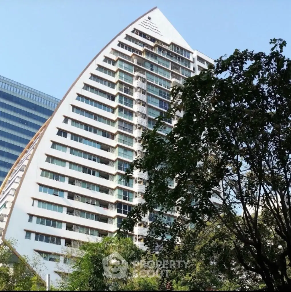 Stunning modern high-rise building with unique architectural design and lush greenery.