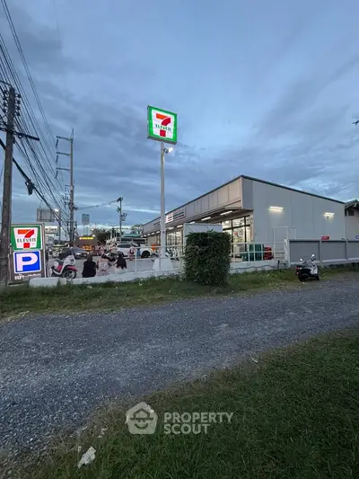Modern convenience store exterior with parking and signage at dusk, showcasing a well-lit and accessible location.