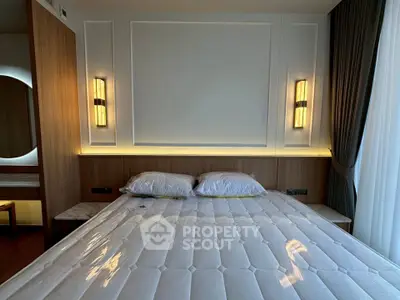 Luxurious bedroom with modern lighting and elegant wood paneling, featuring a plush mattress and stylish decor.