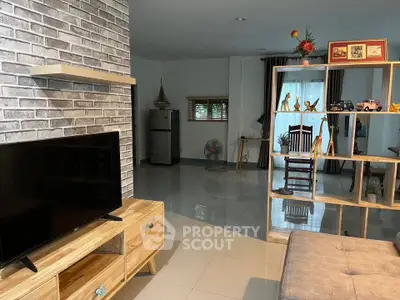 Stylish living room with modern decor and open layout, featuring a TV and decorative shelving.