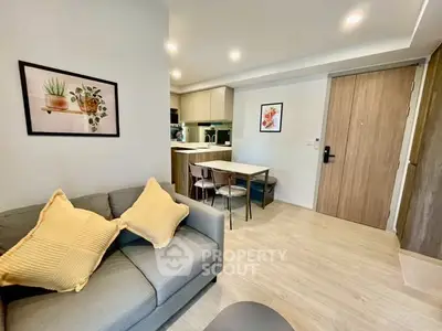 Modern living room with cozy sofa and stylish kitchen in open layout apartment.